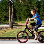 Child riding a bicycle through The Oaks RV Park during a spring camping trip in Andalusia, Alabama