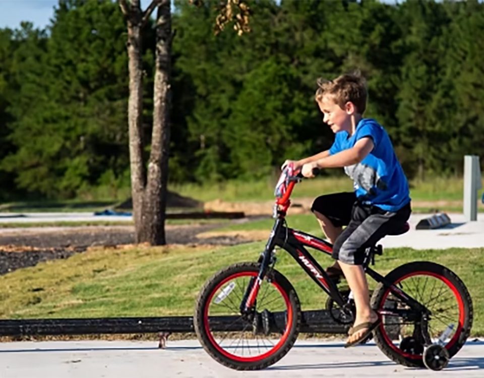 Child riding a bicycle through The Oaks RV Park during a spring camping trip in Andalusia, Alabama