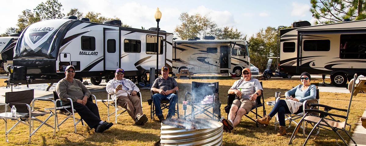 Working RV campers relaxing around a campfire during an extended stay at The Oaks RV Park in Andalusia, Alabama