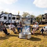 Working RV campers relaxing around a campfire during an extended stay at The Oaks RV Park in Andalusia, Alabama