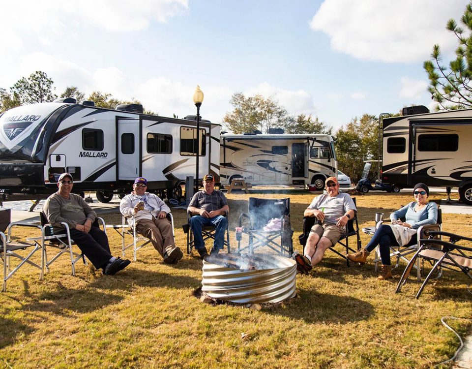Working RV campers relaxing around a campfire during an extended stay at The Oaks RV Park in Andalusia, Alabama